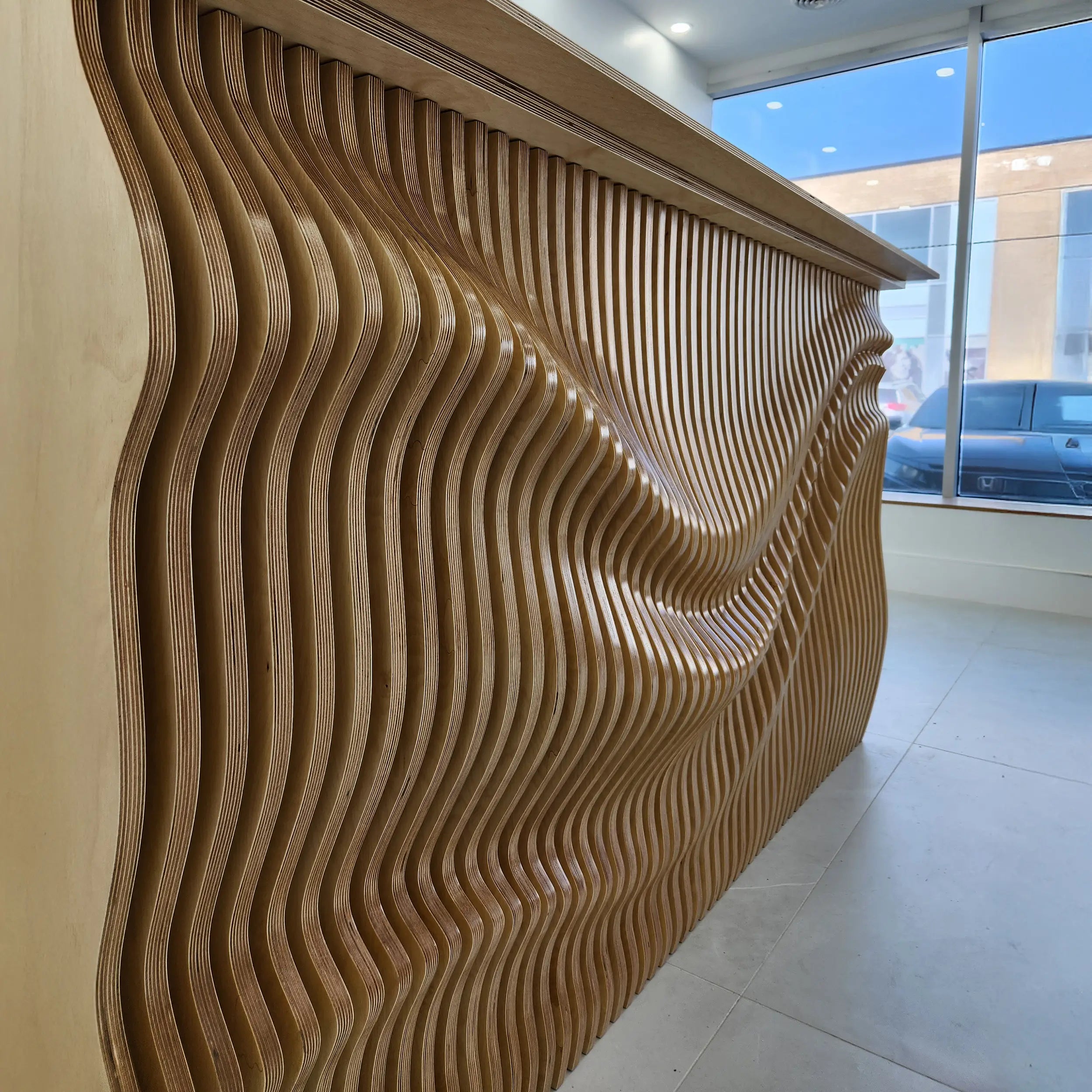 Wooden reception desk with wavy design in a modern interior setting
